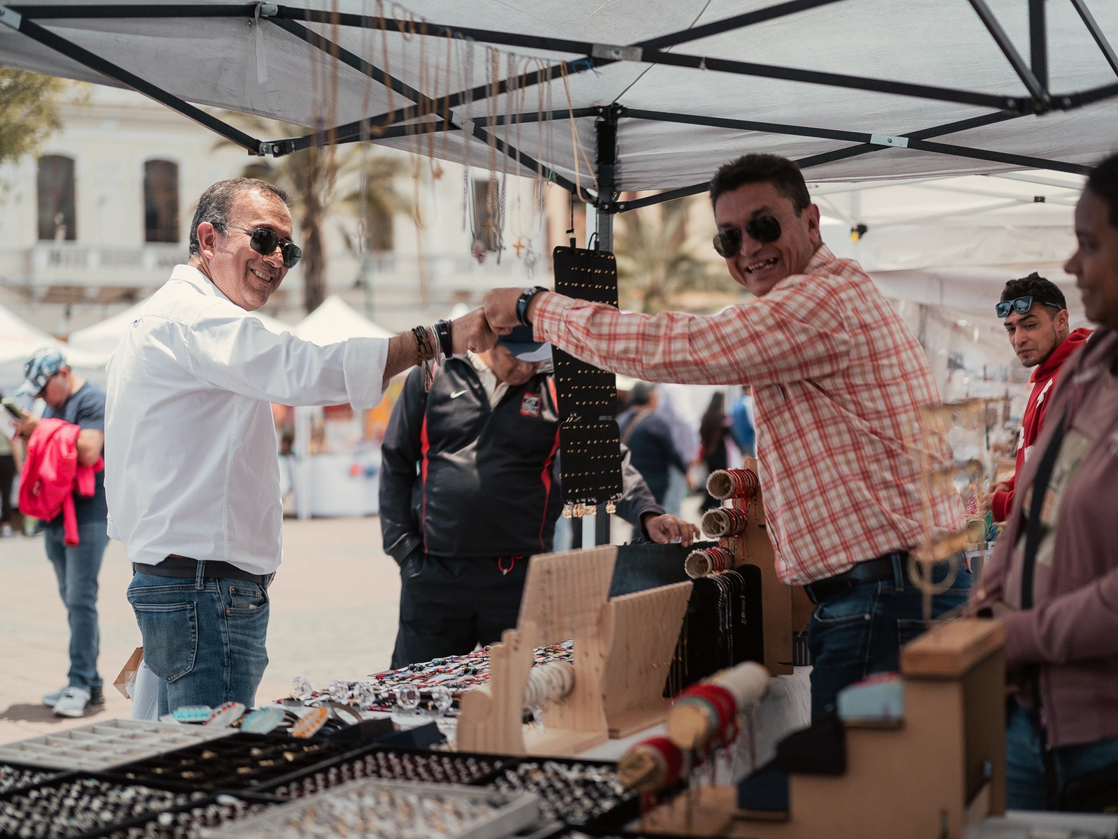 Doryan saluda a un comerciante durante un recorrido actual por una feria.