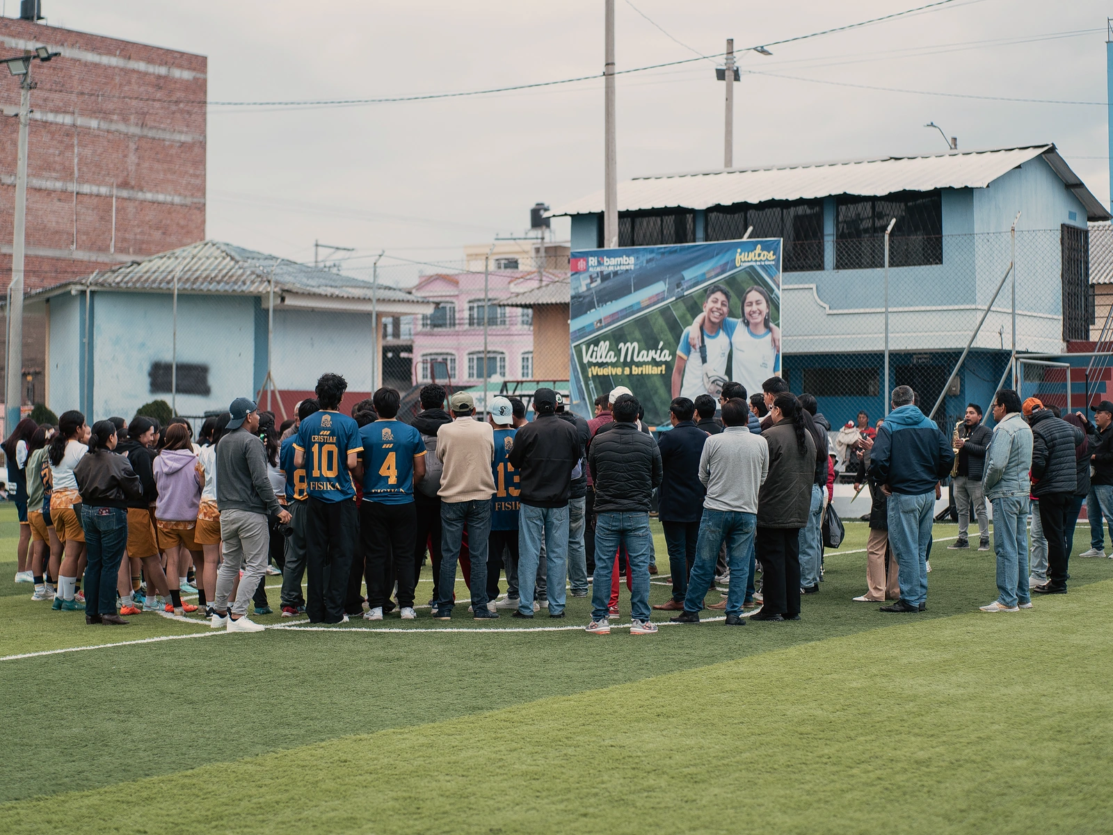 Jugadores y asistentes reunidos sobre una cancha de fútbol.