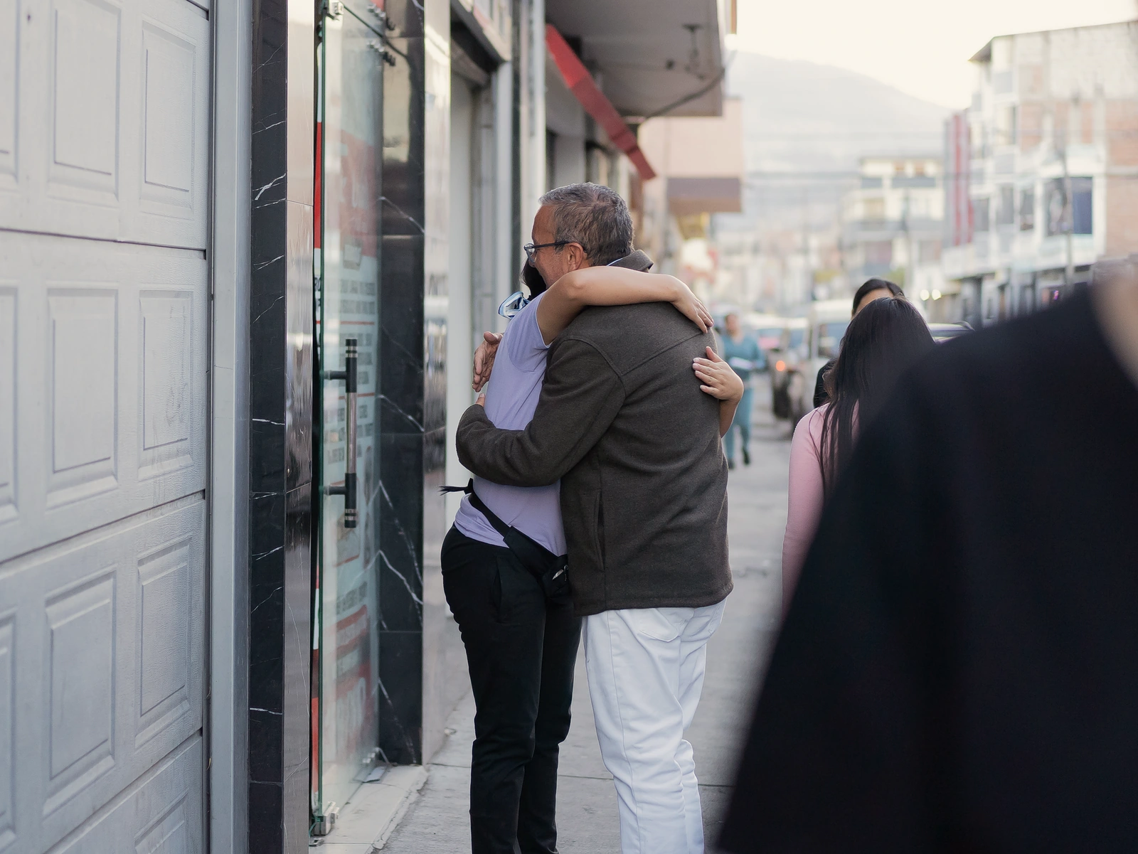 Un saludo y un abrazo durante un recorrido por una calle de la ciudad.